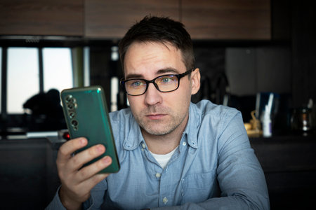 male use modern cellphone gadget, texting or messaging on wireless internet. Caucasian man in...