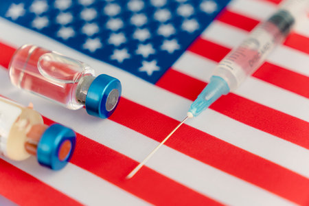 Pharmacology and Medicine USA concept. vaccine against coronavirus covid. Vaccine ampoules, syringe against the background of national flag. national pharmaceutical industry.の写真素材