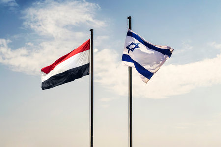 Concept of a Conflict between Isreal and the Yemen. flags of Yemen and Israel on a blue background of cloudy sky. negotiations between Yemen and Israel concept.の写真素材