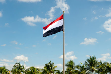 Yemen national flag waving in beautiful sky.の写真素材