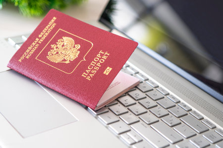 Passport of the Russian Federation on a gray laptop keyboard. Online registration. passport of a foreign citizen. Registration by passport. Ticket purchases.の写真素材