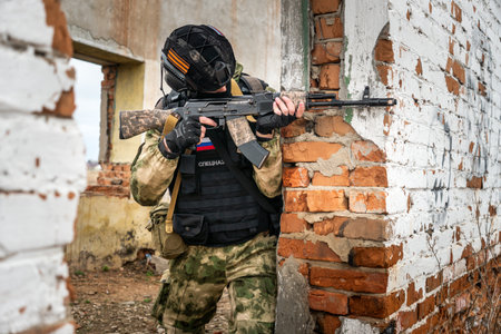 Soldier or militiaman in camouflage with assault rifle fighting in ruins. A special forces soldier storms a destroyed building. The concept of war and military anti-terrorist exercises.の写真素材
