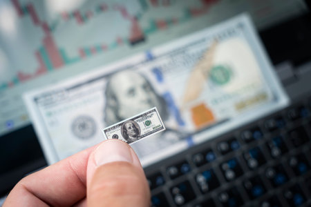 a small bill of one hundred dollars against the background of money and a chart on the forex market....