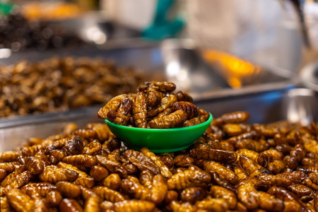 Fried insect larvae on sale in market in Cambodia. Exotic Thai street food snack.の写真素材