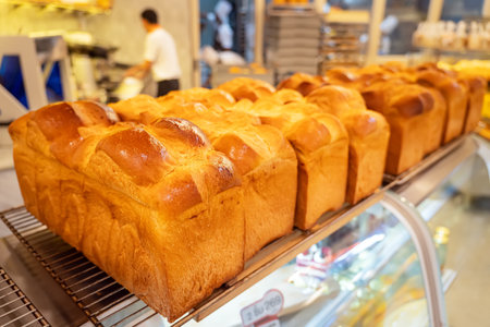 bread displayed by the baker. Breads with a golden crust. Loaves of bread assortment. fresh pastries on the counter in the store.の写真素材
