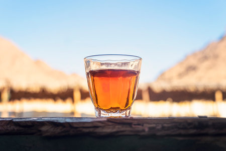 Tea in glass stands on a wooden table against the background of deserted houses.
