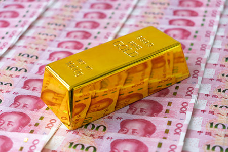 Gold bar on Chinese yuan bill banknotes background. Concept of gold future trading, asset commodity trading or buy gold bars for investment.の写真素材