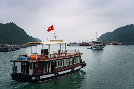 Tourist ship sailing among floating fisherman's village in ha long bay, northern vietnamの写真素材
