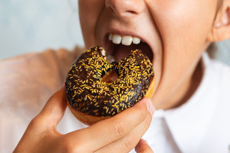 Little girl eating donut messily. The girl is eating sweet pastries.