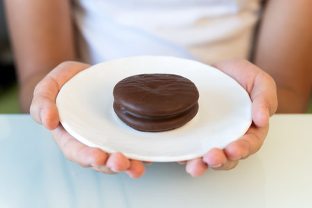 Tasty sweet choco pie in a white plate on the girl's hands.の写真素材
