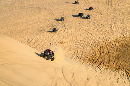 A buggy is racing at high speed over a sand dune in the desert. Arab entertainment in the desert. 4x4, travel in off-road vehicles. off road sportの写真素材