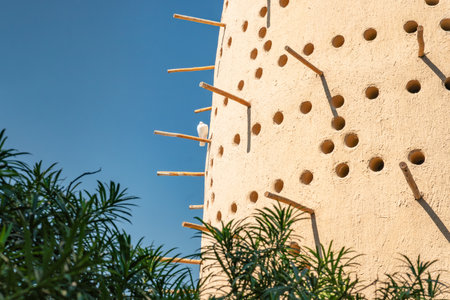 A traditional Arab dovecote made of bricks against a blue sky background.の写真素材