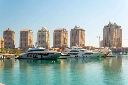 Doha, Qatar- Arabia marina in the Peral Doha, Qatar sunset shot showing Docking boats and yachts in the Arabic gulf and residential buildings in back groundの写真素材