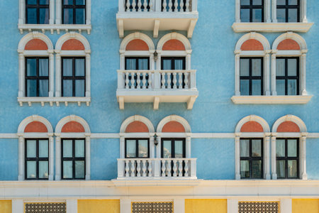 Vintage windows and balconies on blue wall. the facade of the building is in the Old European style of architectureの写真素材