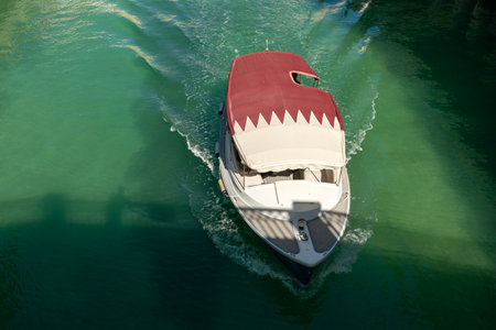 A pleasure boat with the Qatari flag sails along the canal in the little Venice district....