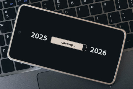 the concept of changing the year from 2025 to 2026. smartphone on the computer keyboard with the process of loading the new year. end of 2025の写真素材