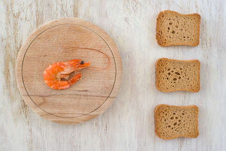 composition with a shrimp and rusks on a kitchen tableの写真素材