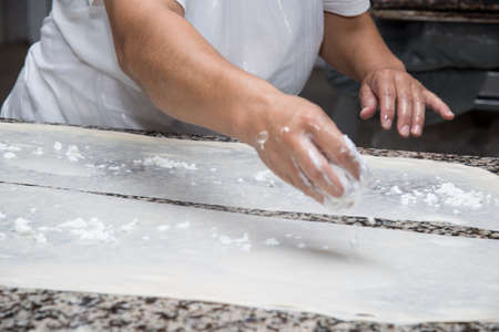 close up of female hands kneading dough and making banitsa - typical bulgarian pastry