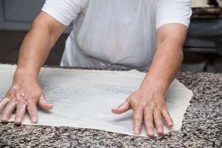 close up of female hands kneading dough and making banitsa - typical bulgarian pastryの写真素材