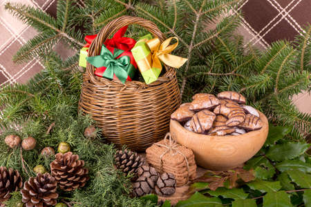 Christmas decoration with fir branches, mistletoe, wood cookies and gifts - still lifeの写真素材