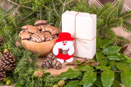 Christmas decoration with fir branches, mistletoe, wood cookies and gifts - still lifeの写真素材