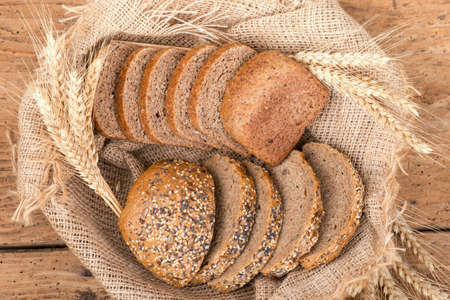 Rustic bread and wheat on an old vintage planked wooden table. Old wood background with free text...
