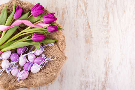 easter eggs and flowers over white wooden table - selective focus, copy spaceの写真素材