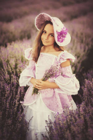 little girl dressed as a princess in a field of lavenderの写真素材