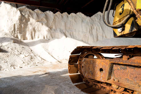 salt production - pile of salt and excavator at saltworks - selective focus, copy spaceの写真素材