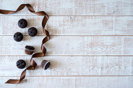 Chocolate muffins on a white rustic wooden table - selective focus, copy space
