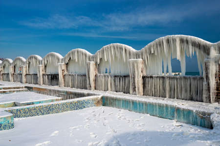 Icicles over the arches of the abandoned swimming pool by the seaの写真素材