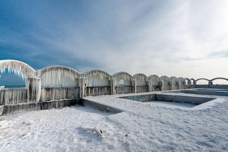 Icicles over the arches of the abandoned swimming pool by the seaの写真素材