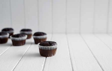 Chocolate muffins on a white rustic wooden table - selective focus, copy spaceの写真素材