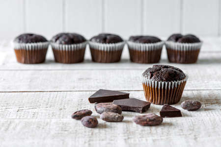 Chocolate muffins on a white rustic wooden table - selective focus, copy space