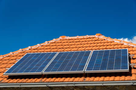 Solar panel on a red roof - alternative electricity sourceの写真素材