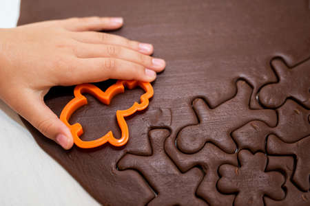 Children's and woman's hand makeing Christmas Gingerbread Cookies - selective focusの写真素材