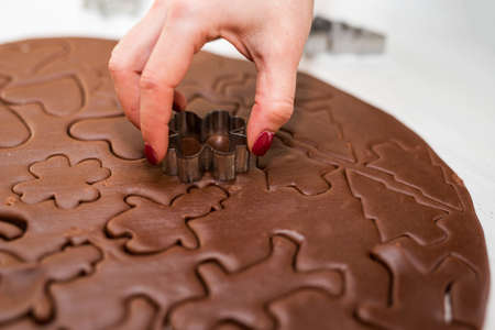 Children's and woman's hand makeing Christmas Gingerbread Cookies - selective focusの写真素材