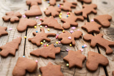 Christmas gingerbread cookies with different shapes over a vintage wooden table