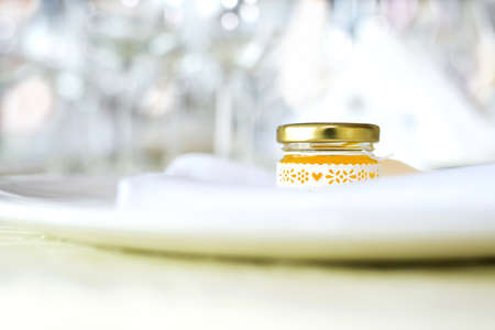 Guest table and jar of honey with lace ornaments. As a compliment to the guests. - selective focus,...