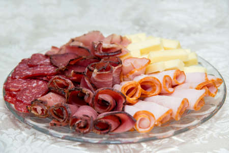 Different types delicacies of meat and cheese arranged in a plate over light background - selective focusの写真素材