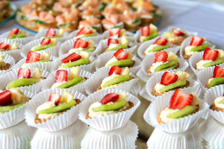 Close up of small sweet canapes arranged on a mirror plate over light background - selective focusの写真素材