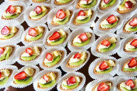 Close up of small sweet canapes arranged on a mirror plate over light background - selective focusの写真素材