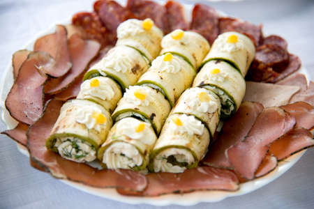 Close up of small canapes arranged on a plate over light background - selective focusの写真素材