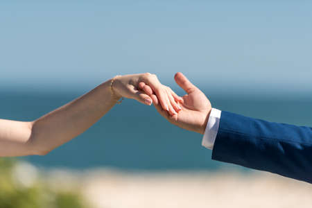 Bride and groom holding their hands - detail. Selective focus, copy spaceの写真素材