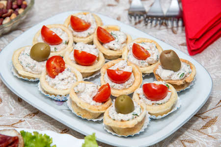 Close up of small canapes arranged on a plate over light background - selective focusの写真素材