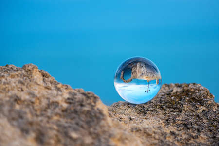 Upside down seascape with the chapel of St. Nicholas at Cape Kaliakra - reflection in a lens ball - selective focus, space for textの写真素材
