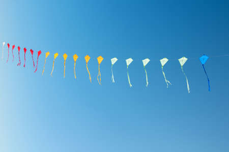 Colorful kites flying in blue skyの写真素材
