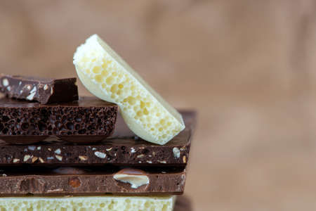 Different kinds of chocolates with nuts cocoa powder and mint - selective focus, wrapping brown...