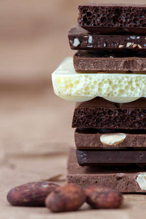 Different kinds of chocolates with nuts cocoa powder and mint - selective focus, wrapping brown...
