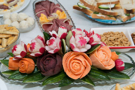Thai Vegetable Carving shape beautiful flower over red beets, carrots and radishes. The buffet at the reception. Banquet service. Party Concept.の写真素材